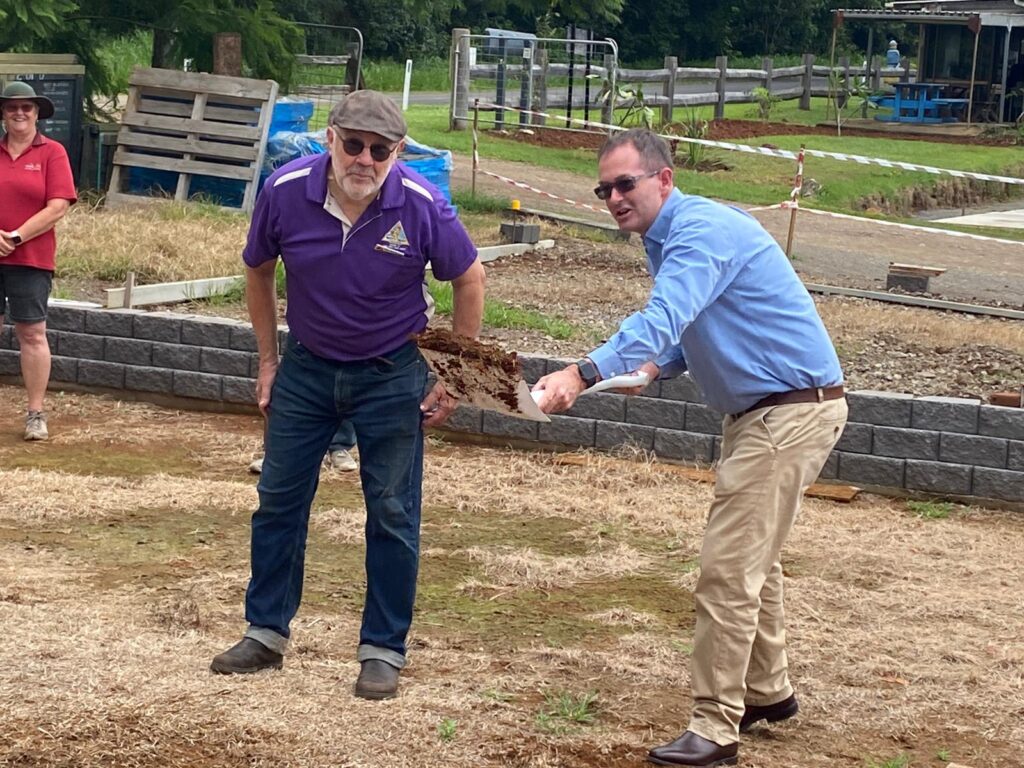 Federal Member for Fisher and Speaker of the House of Representatives Andrew Wallace MP turns the sod while Maleny and District Men’s Shed President Kevin Trevarthen looks on.